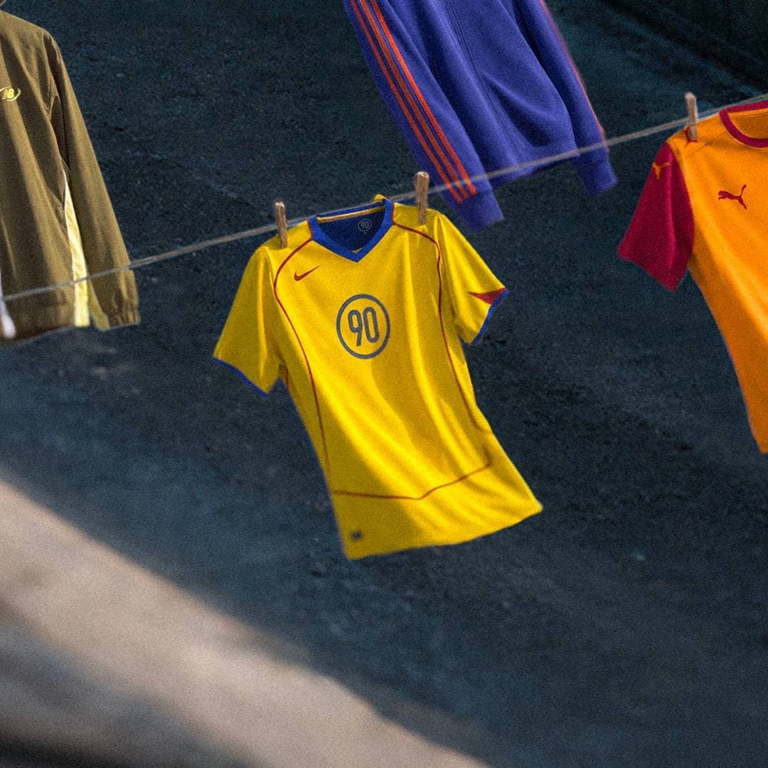 A yellow football shirt and retro track jackets are displayed on washing lines.