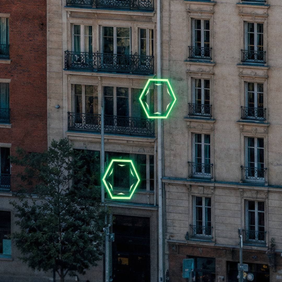 Two glowing green target icons near apartment windows in an urban block.