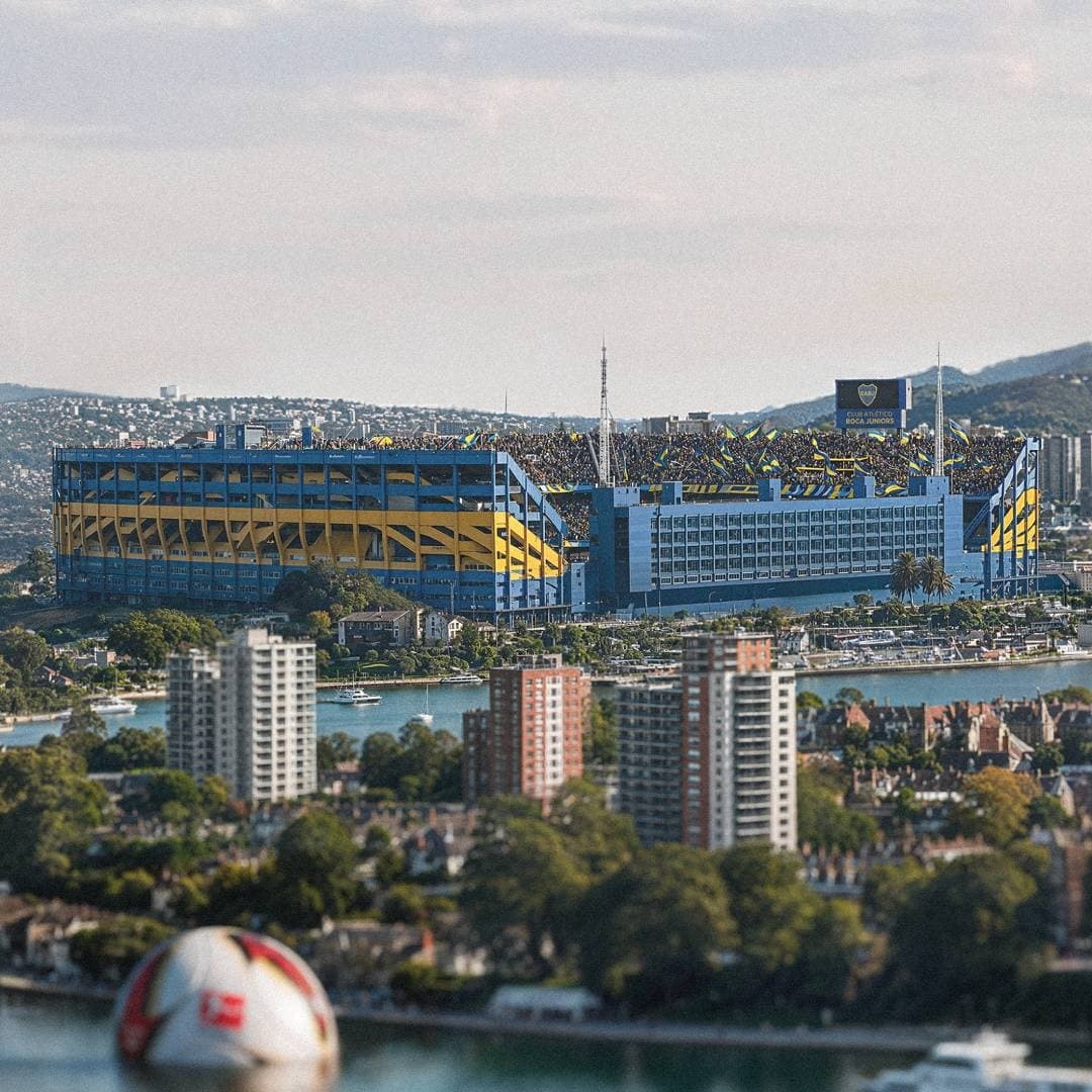 La Bombonera stadium with Boca colors rising in the city skyline.