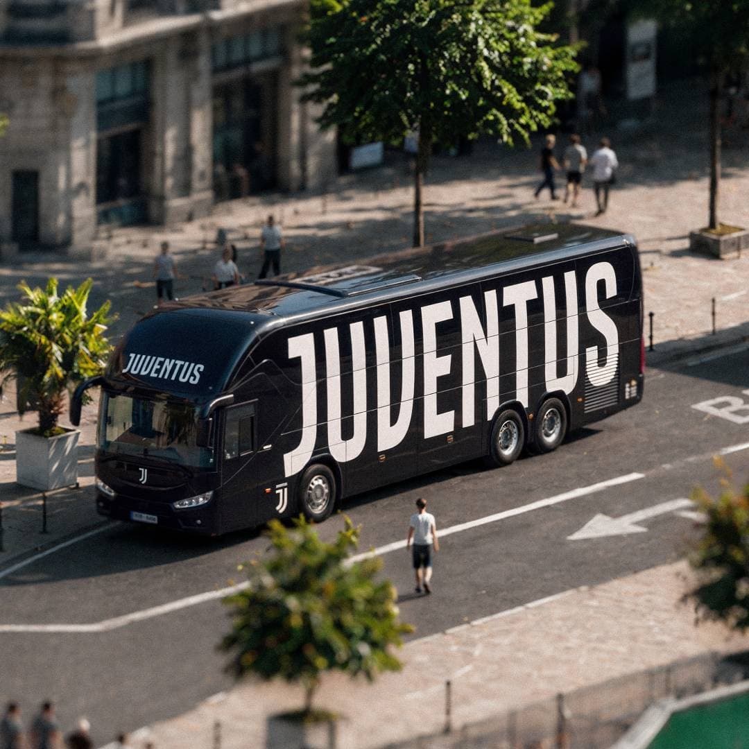 Black Juventus bus with large white branding in a city street from above.