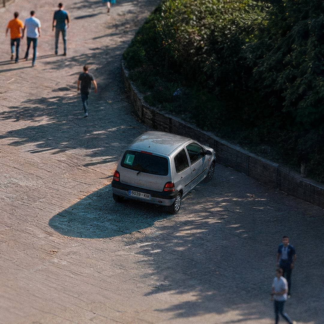 Piccola utilitaria argento con targa da neopatentato parcheggiata in piazza.